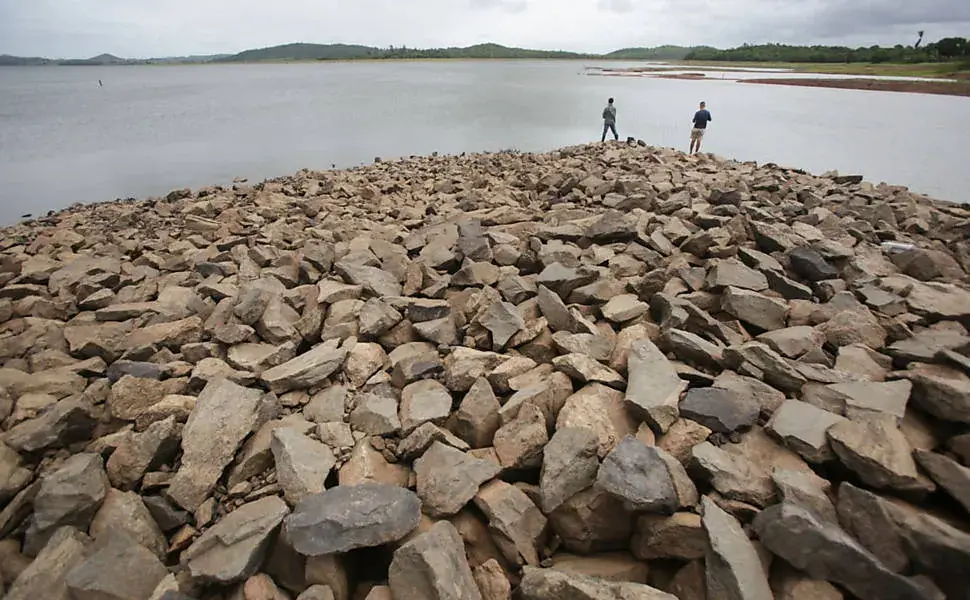 Espelho d'água da Barragem Joanes II vista da margem, com vegetação ao redor