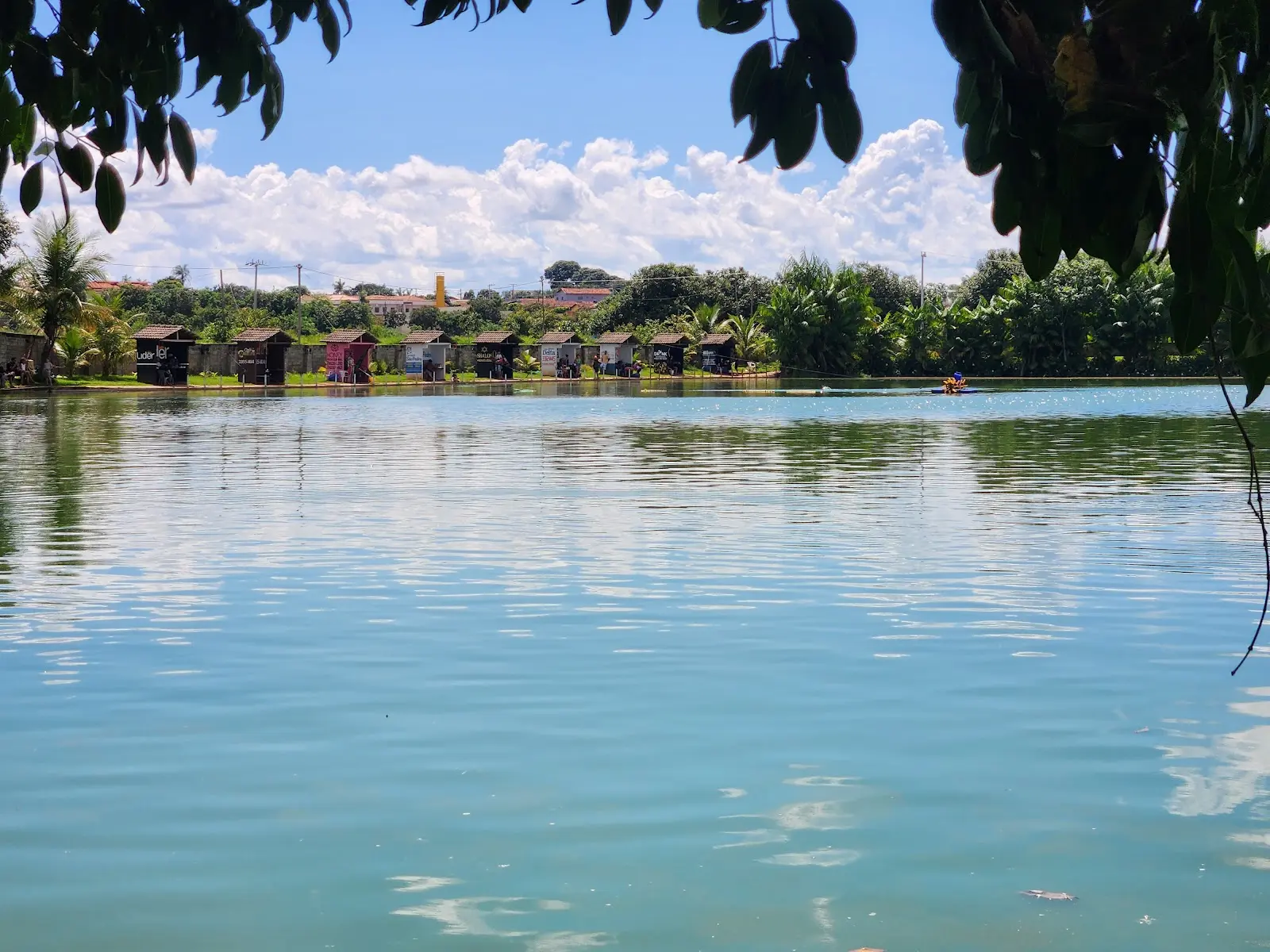 Lago do Clube de Pesca Recanto do Pirarucu com a fileira de quiosques na margem, em Itapuranga