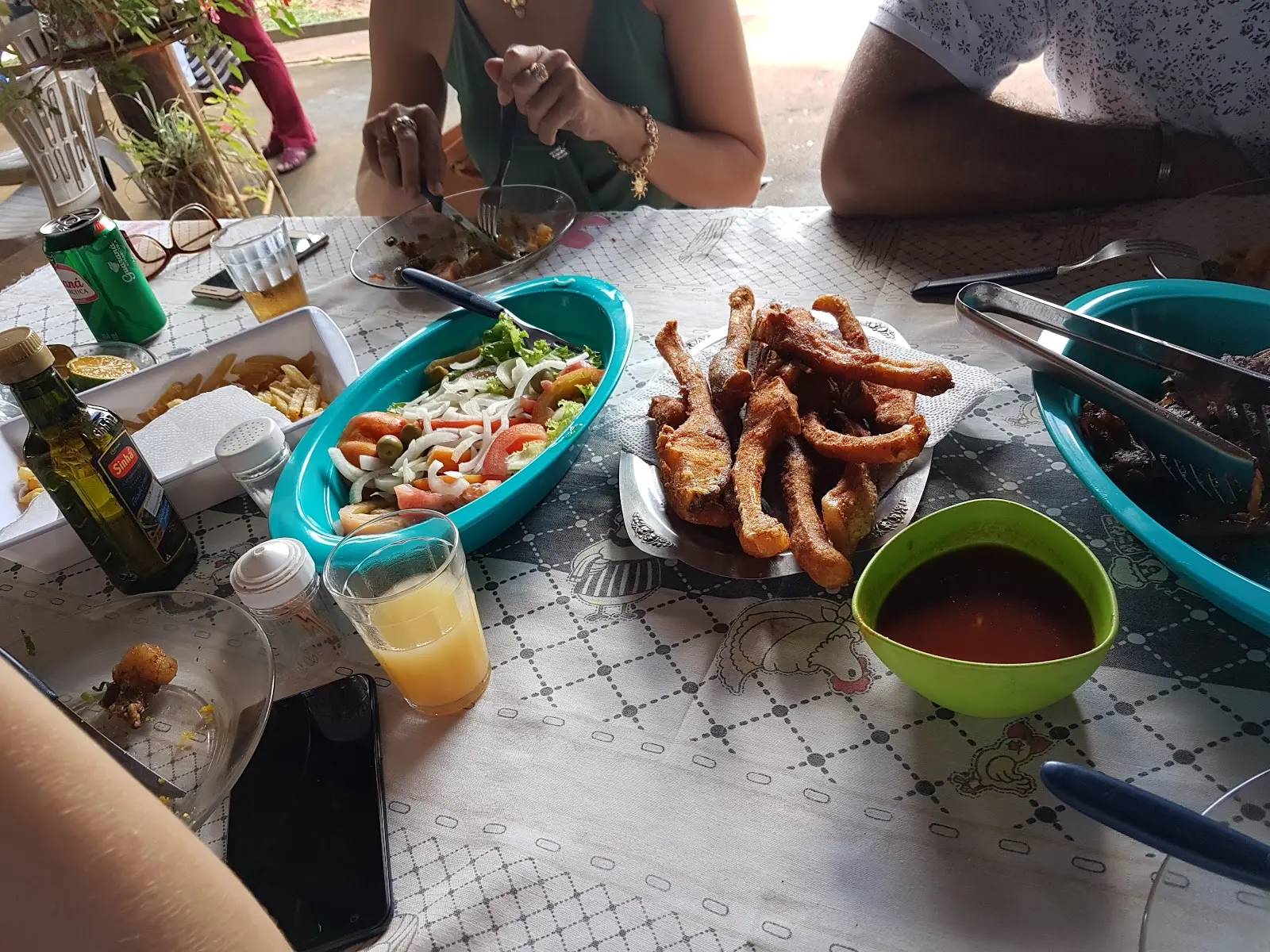 Mesa com porção de peixe frito, salada e molho no Pesque e Pague Canaã, em Ceres
