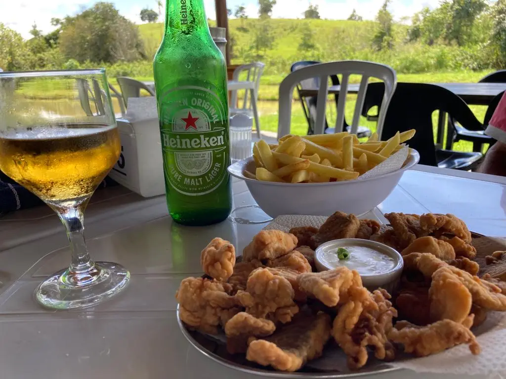 Porção de peixe frito com batata frita e cerveja numa mesa do Pesque Pague Cedro, em Anicuns