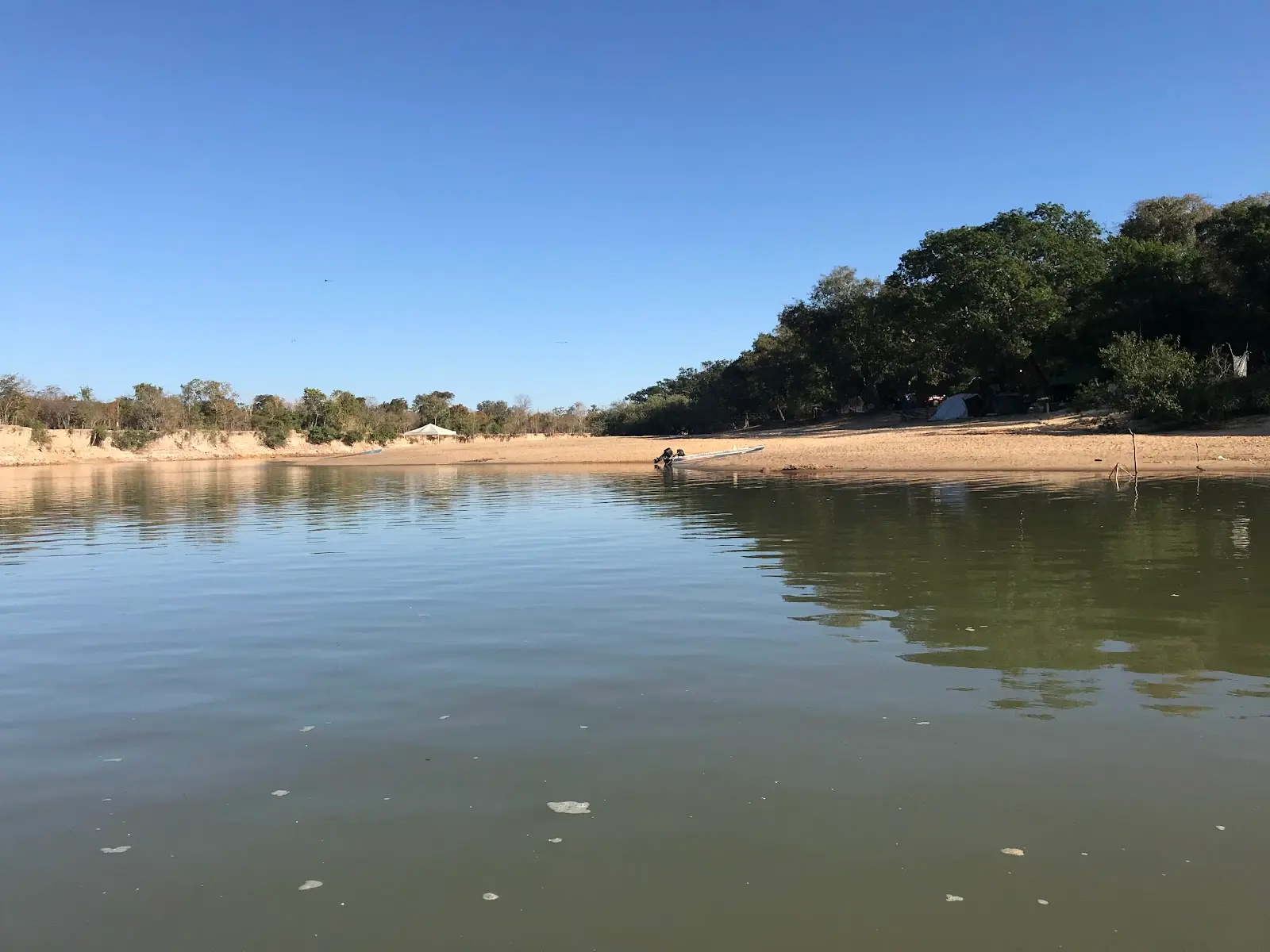 Trecho de rio com margem de areia e mata ciliar no Pite Clube de Pesca, em Nova Crixás