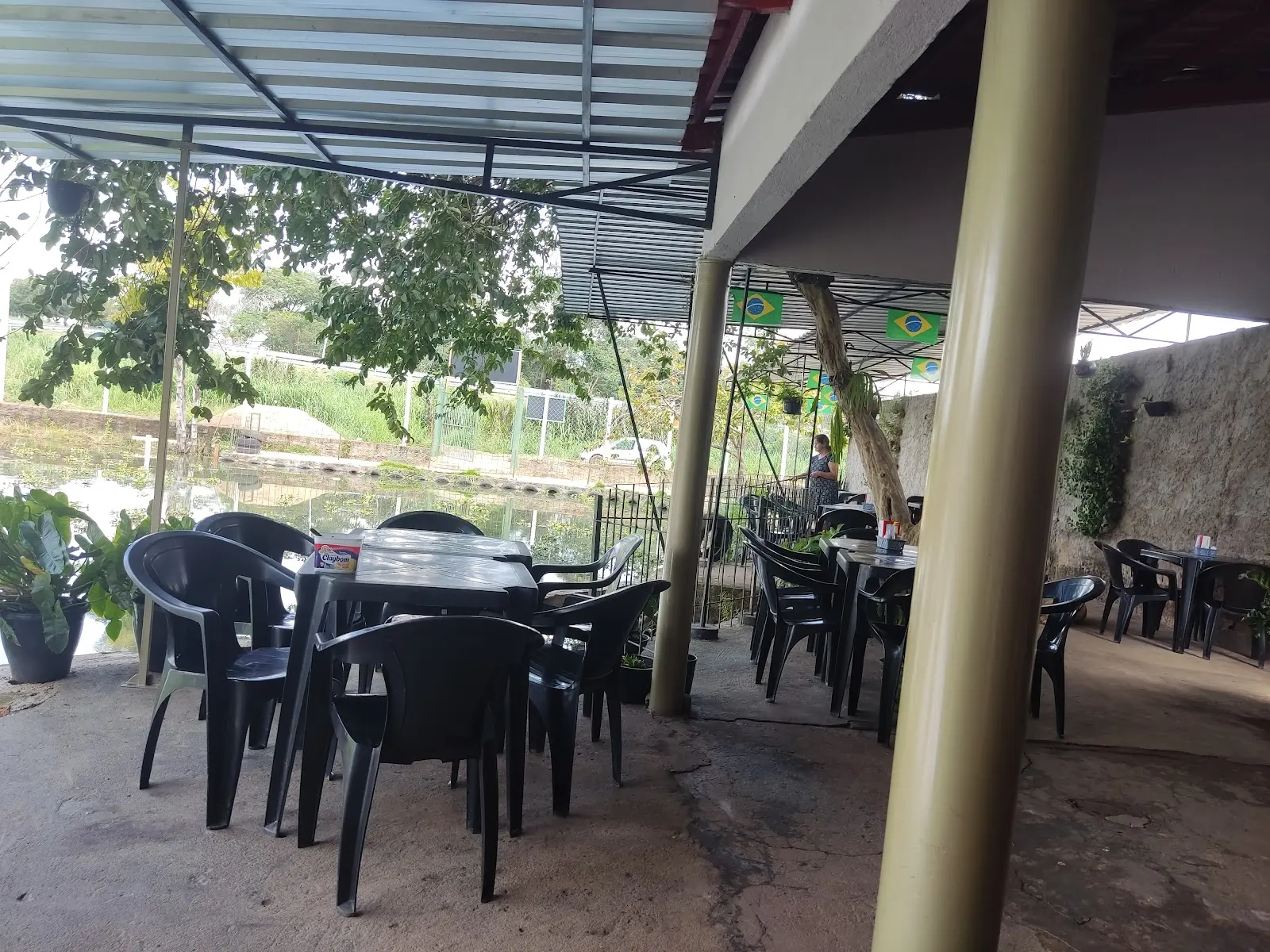 Área coberta com mesas do Pesque e Pague São Luiz, com o tanque ao lado
