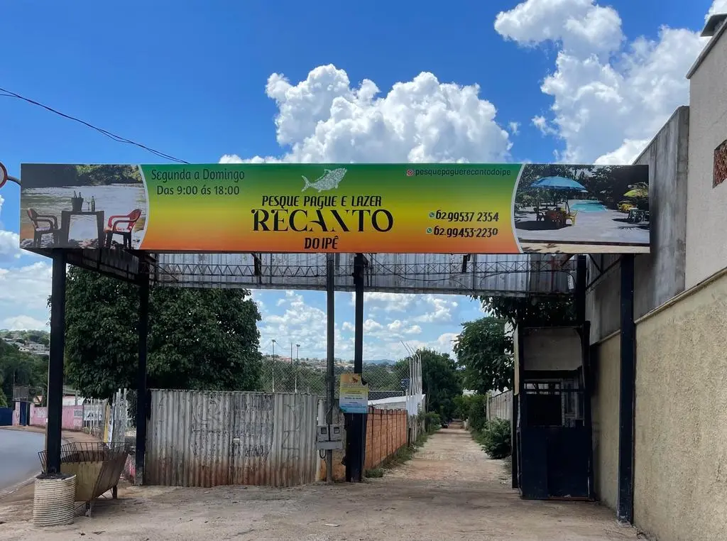 Portal de entrada do Pesque Pague e Lazer Recanto do Ipê, com a placa sobre a estrada de terra