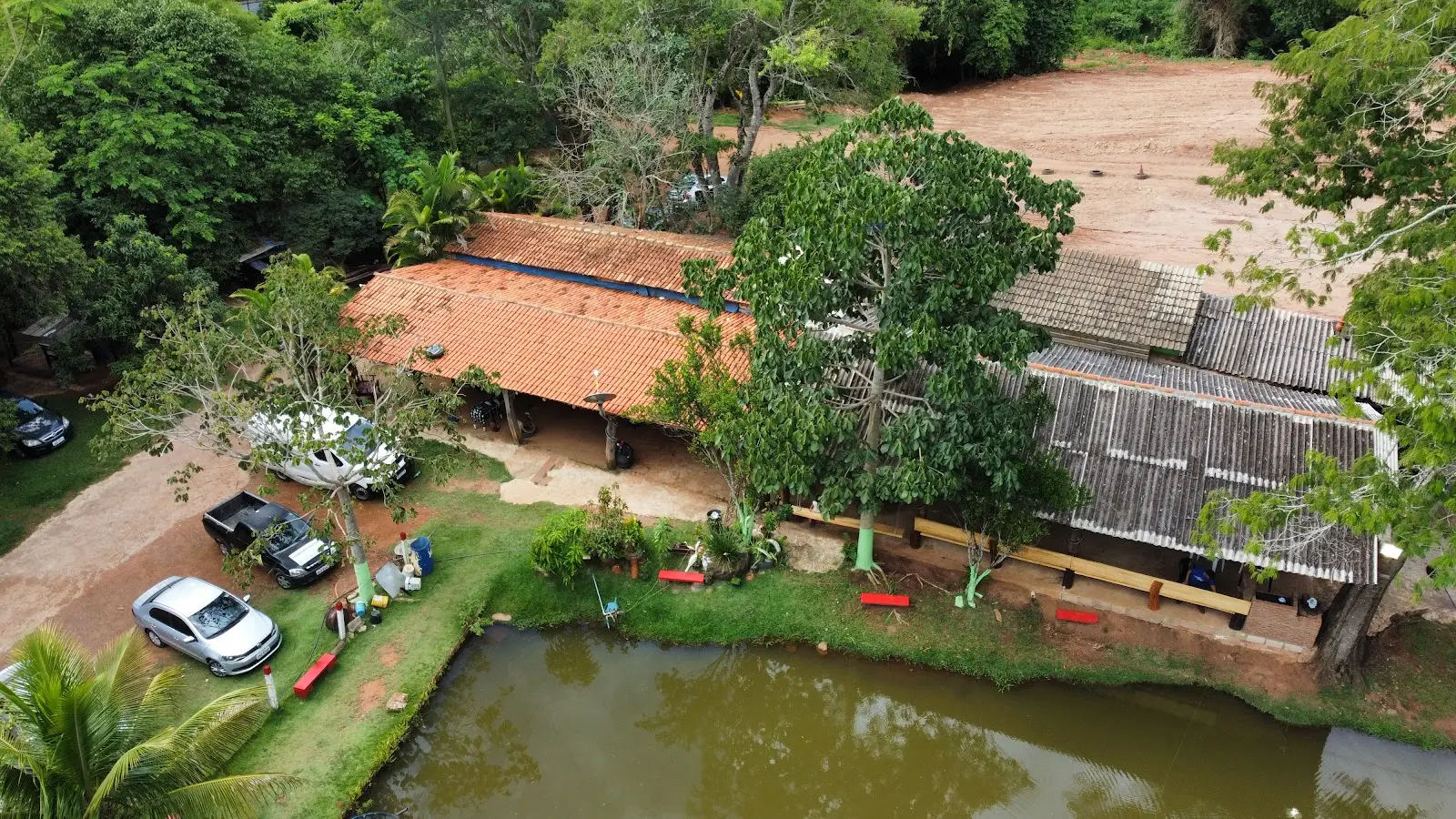 Vista aérea do restaurante de telhado de cerâmica, estacionamento e lago do Pesque Pague Beira da Mata