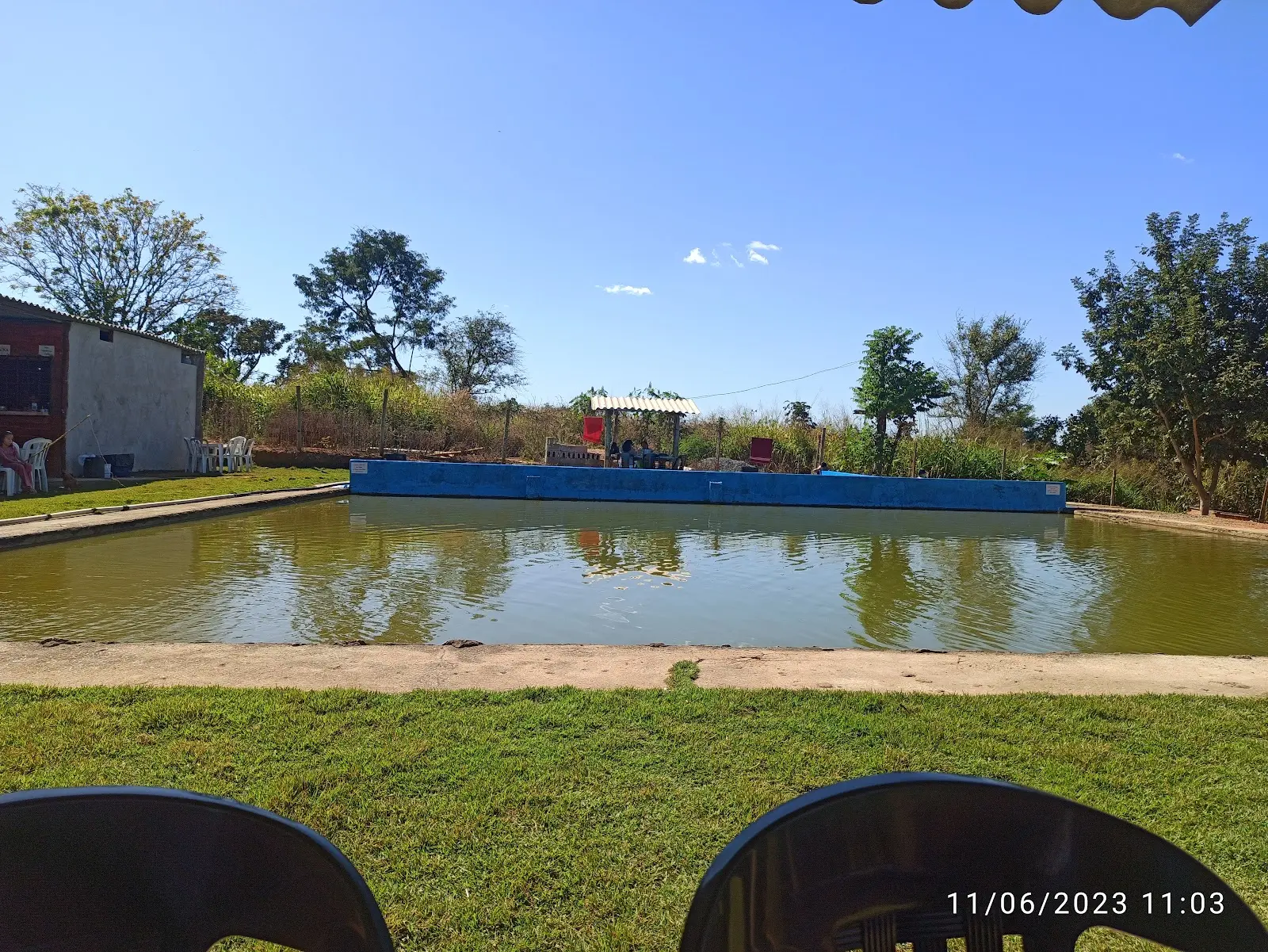 Tanque retangular de pesca com mureta azul ao fundo no Pesque Pague Bom Sucesso
