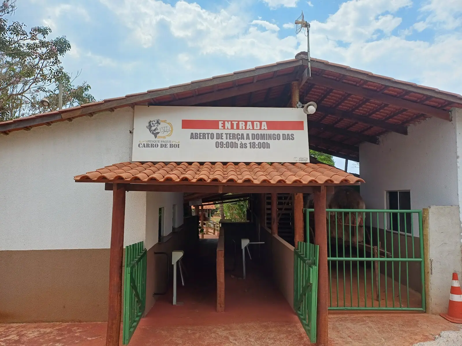 Portaria do Pesque Pague Carro de Boi com placa de entrada e horário de funcionamento