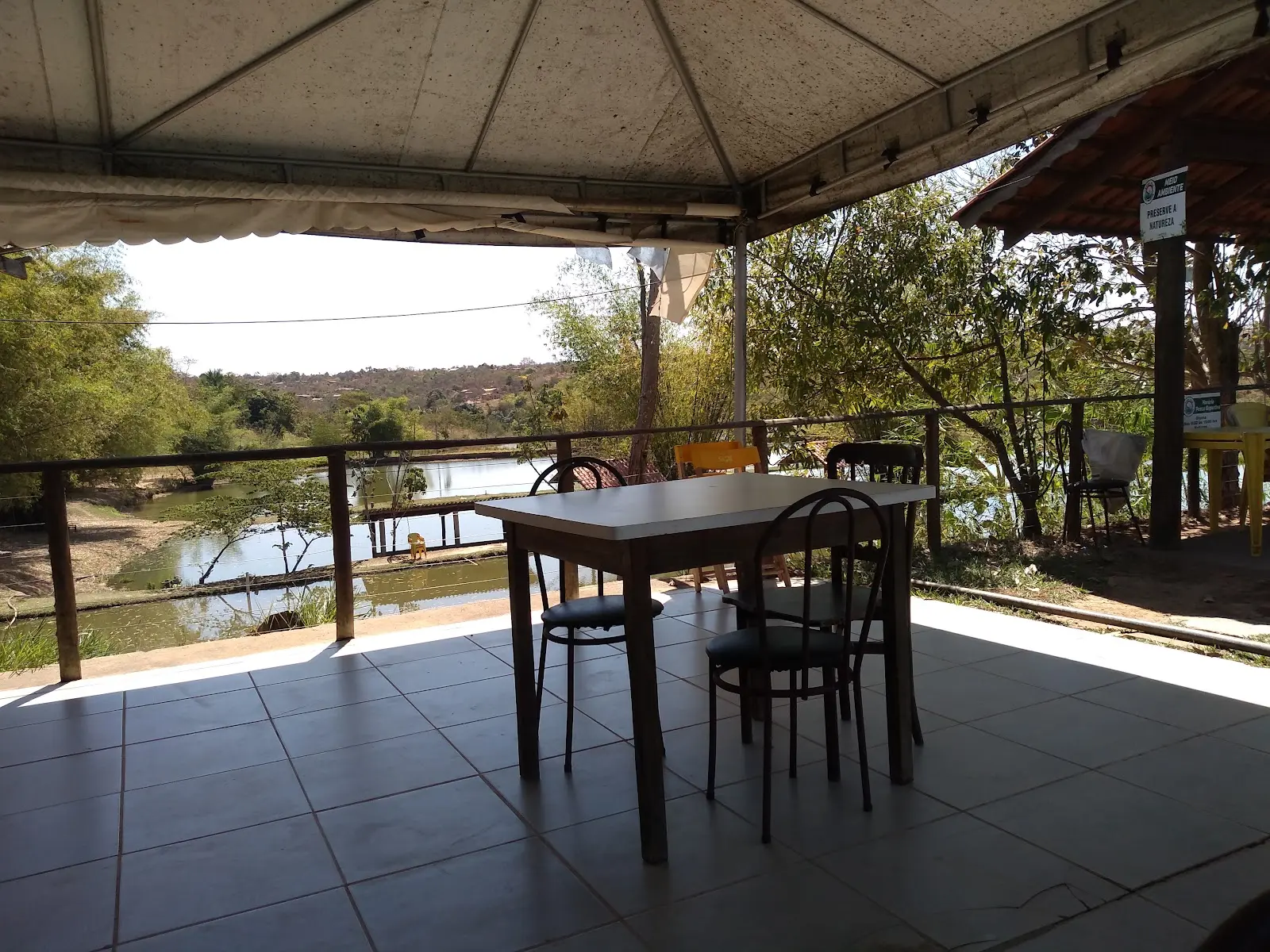 Mesa em área coberta com vista para uma represa do Pesk Pag dos Amigos