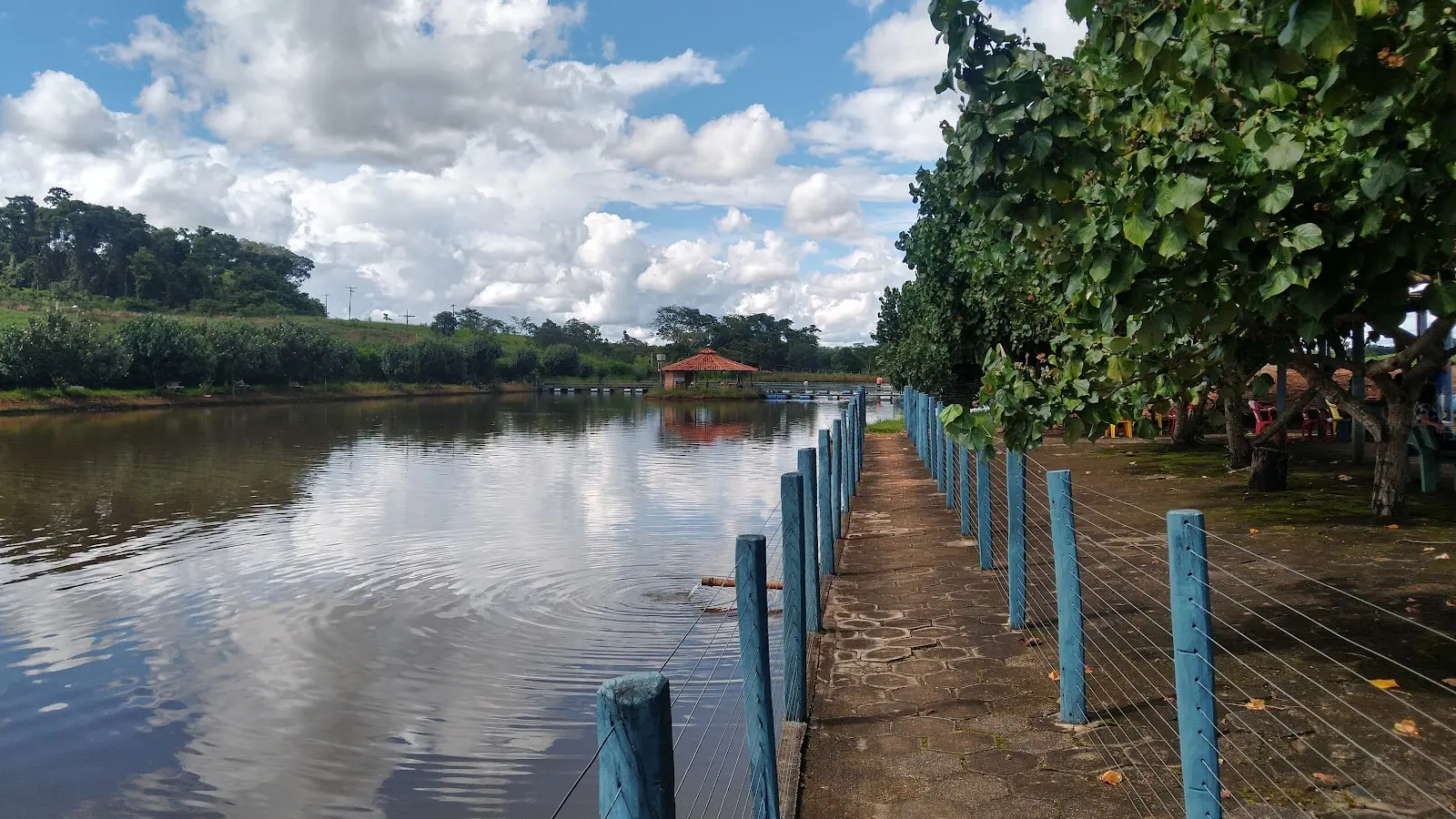 Lago do Pesque e Pague do Sítio com passarela de pedra e cerca azul na margem