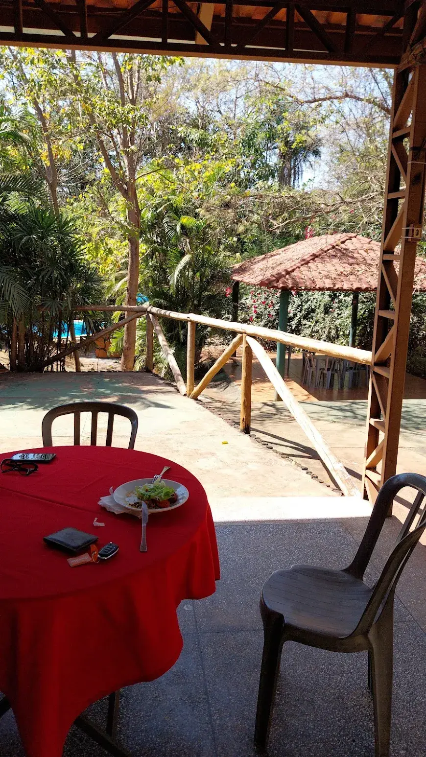 Varanda do restaurante do Pesque Pague Bem-te-Vi com vista para o jardim e um quiosque