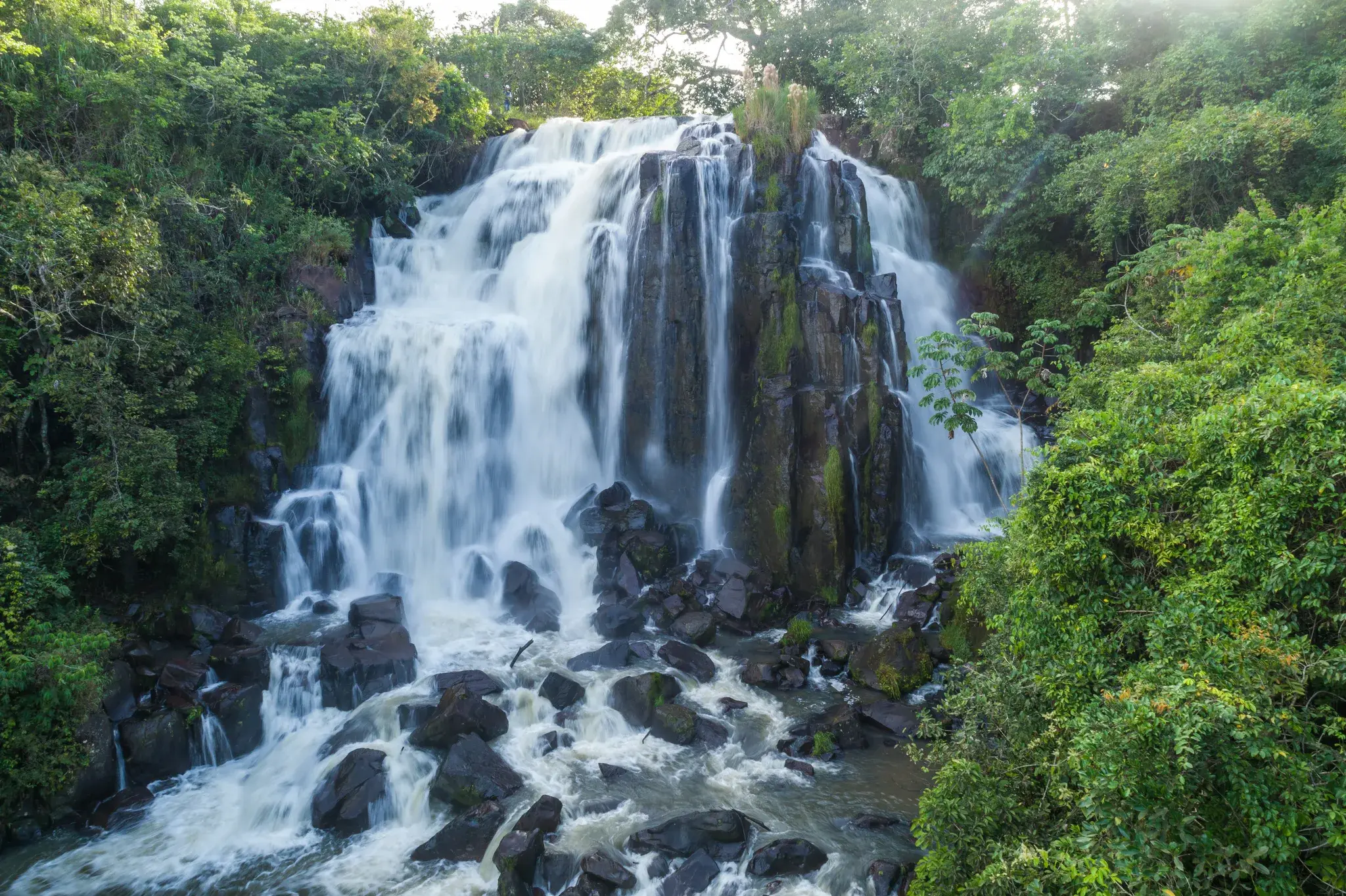 Cachoeira do Rio Verde caindo sobre pedras escuras no meio da mata