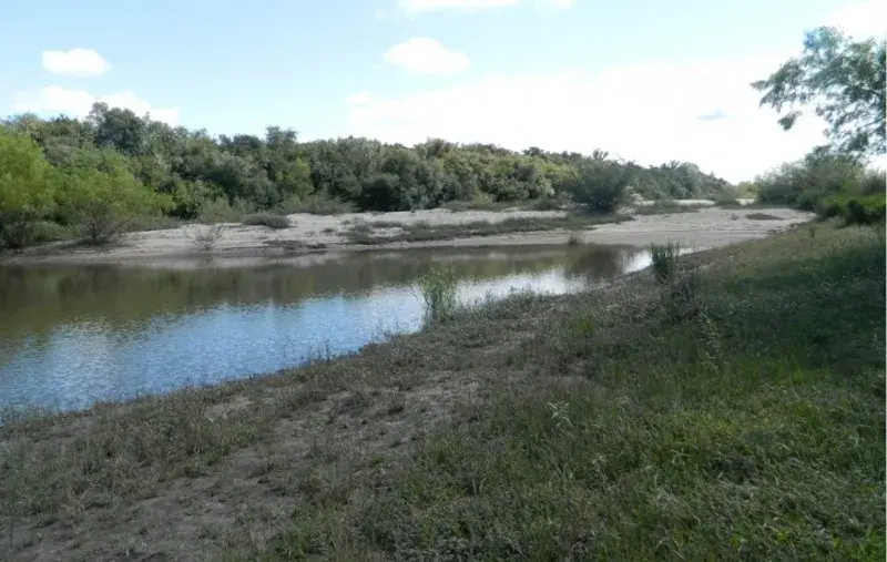Curso largo do Rio Negro correndo pelo campo do pampa, na fronteira entre Brasil e Uruguai