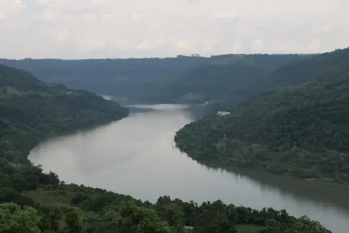 Águas claras do Rio Passo Fundo correndo entre a mata das margens