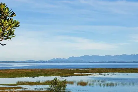 Vista aérea do calçadão de Sombrio às margens da lagoa, com a água ao fundo