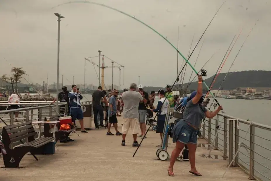 Pescadores arremessando a partir de um deck de pesca