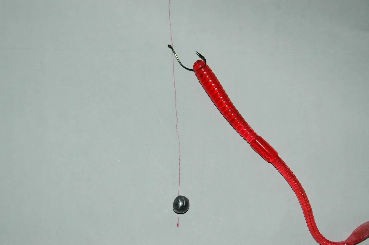 Montagem drop shot: anzol com minhoca de silicone vermelha acima e chumbo na ponta da linha