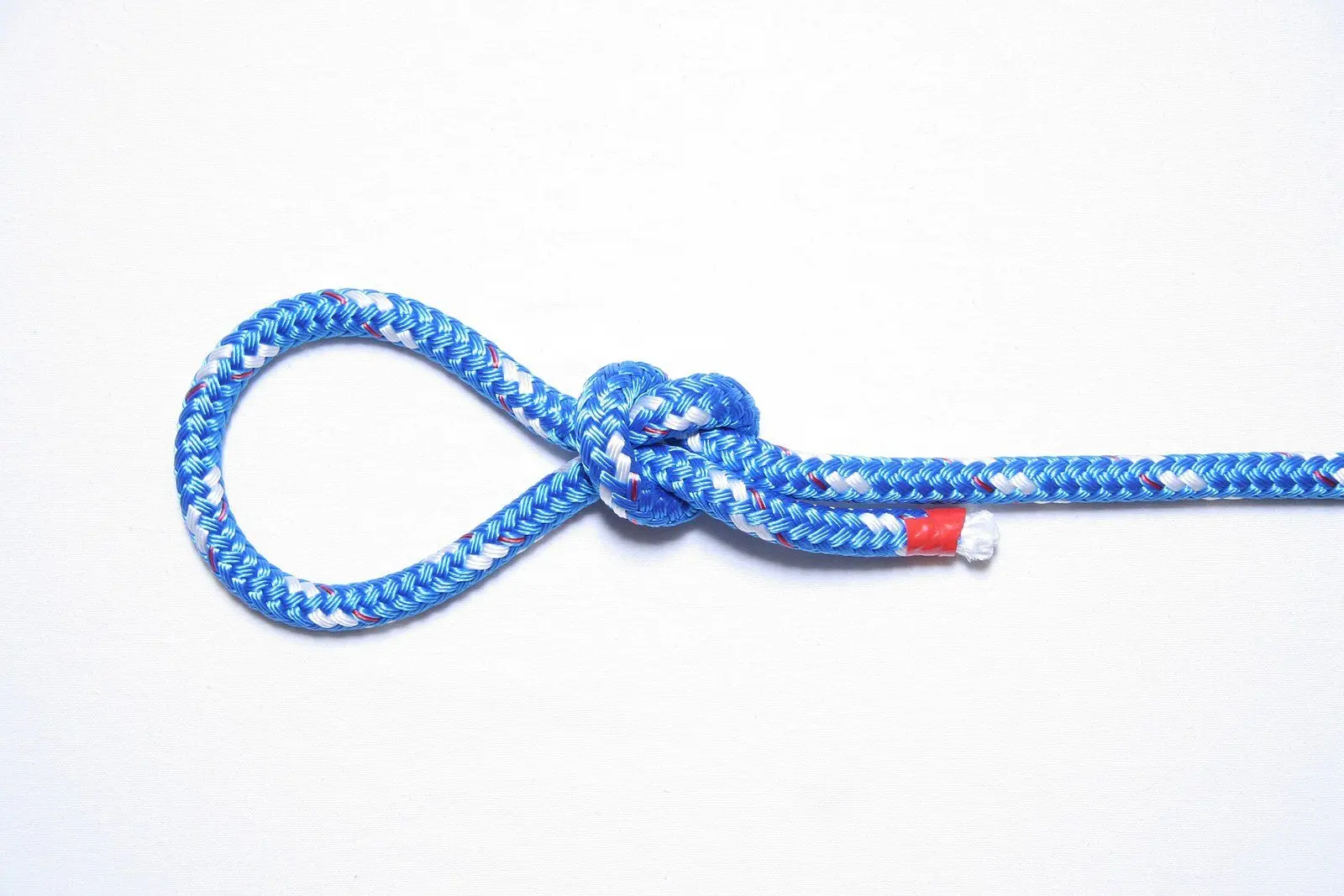 Nó de correr (slip knot) feito em corda azul sobre fundo branco