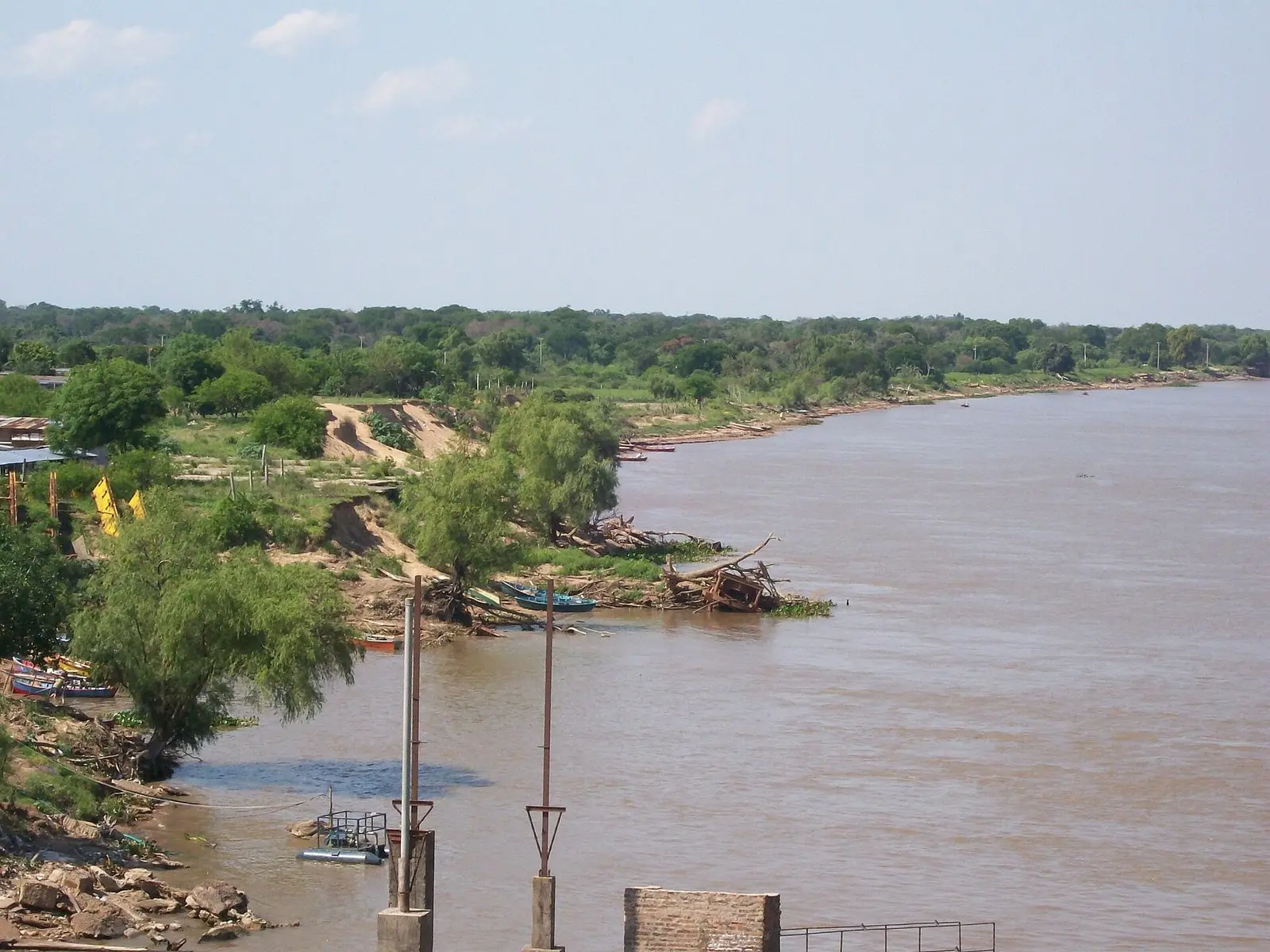 Barrancos altos e erodidos na margem do rio Paraná, com canoas embaixo, no Chaco argentino