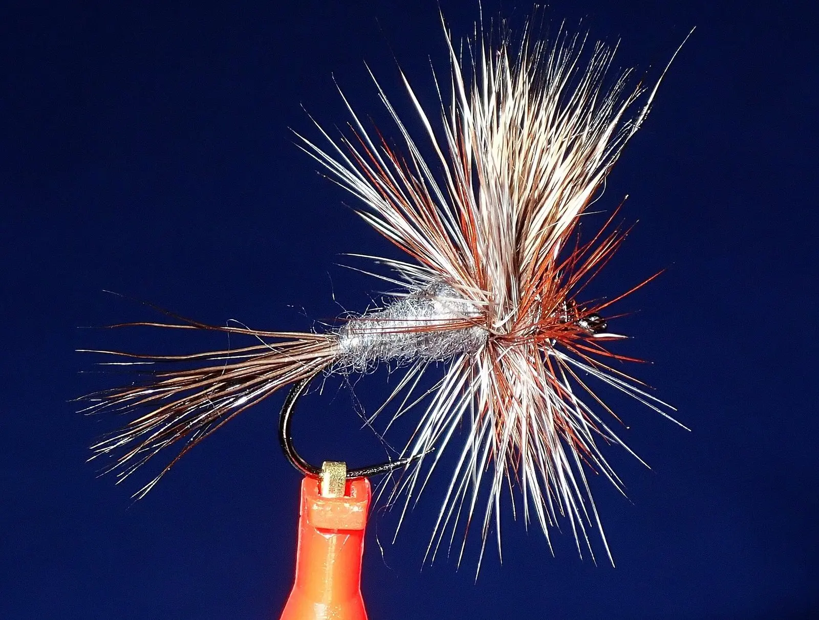 Mosca seca Adams Wulff presa na morsa, com hackle e cauda de pelos armados para flutuar