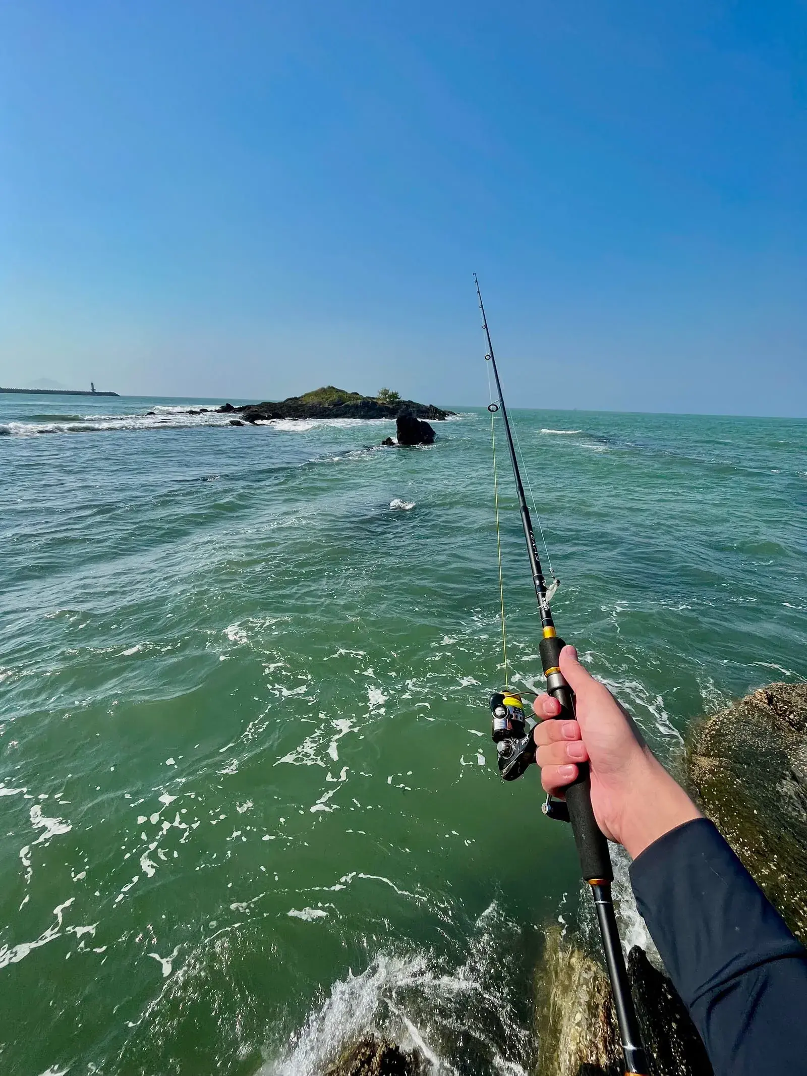 Pescador com vara ultralight e peixe pequeno
