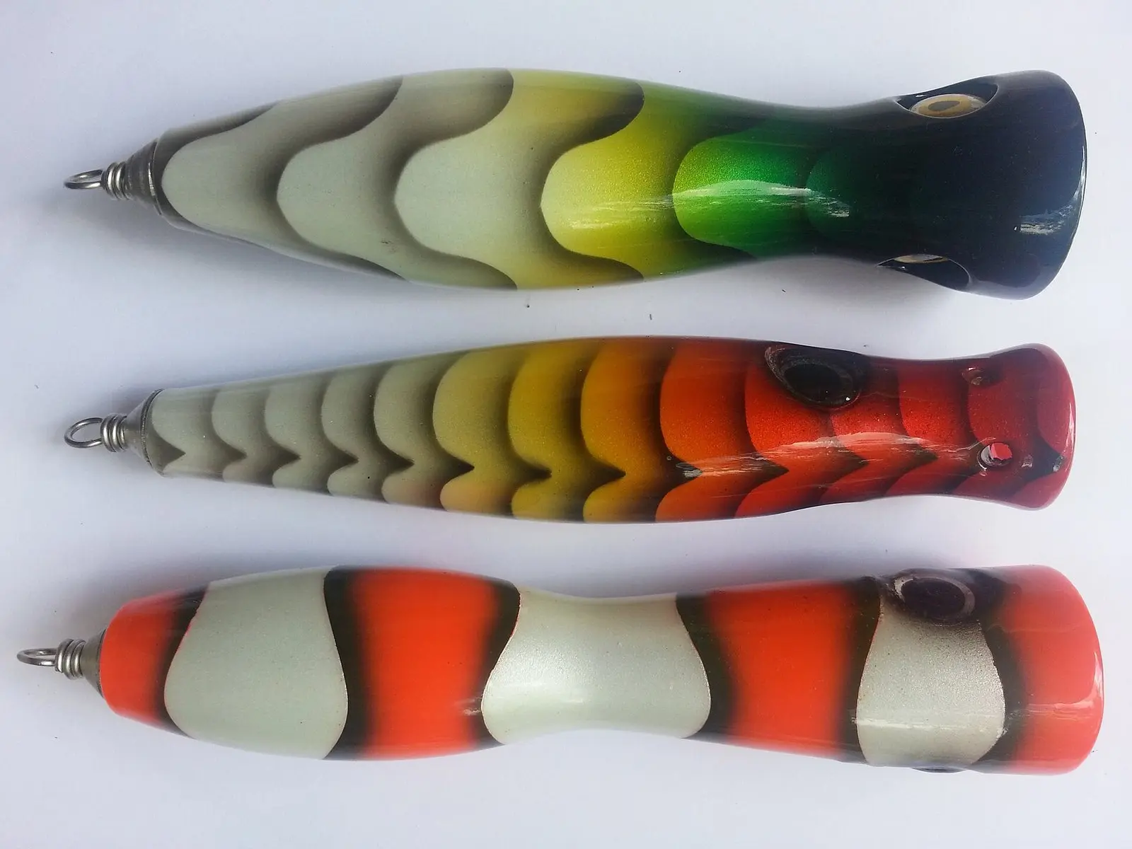Três poppers grandes de madeira pintada, usados na pesca oceânica de xaréu e atum