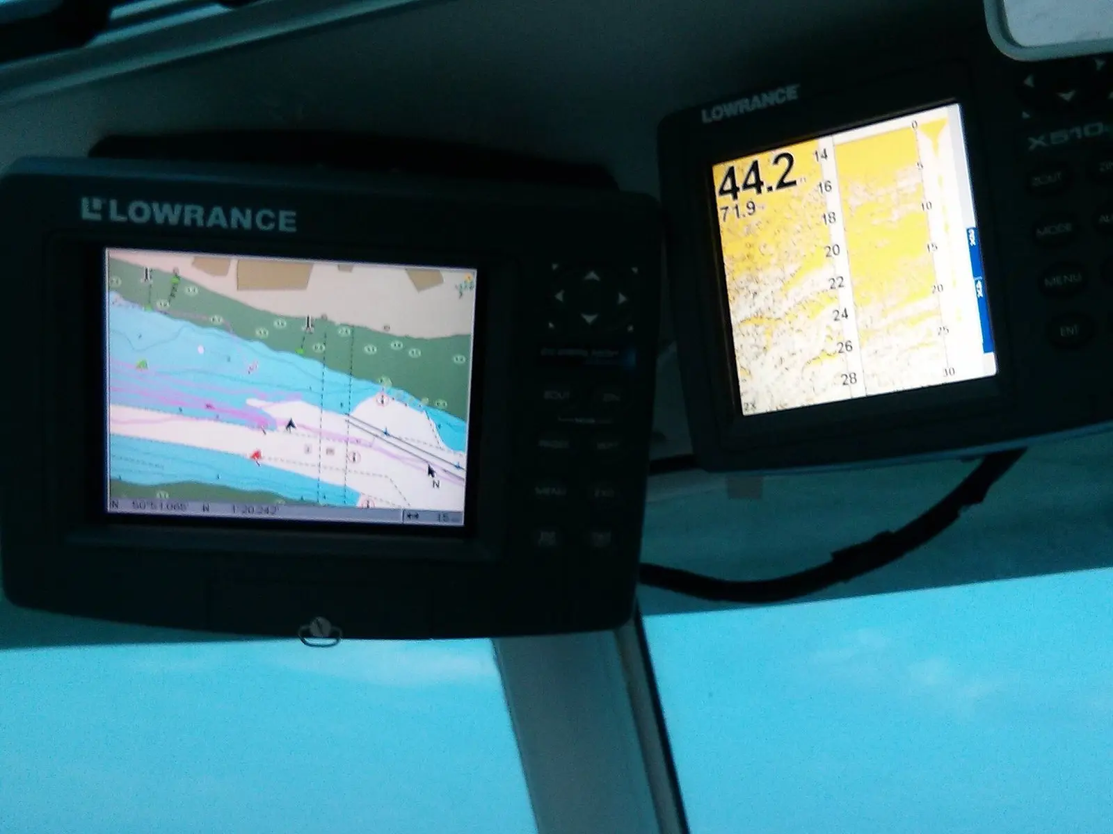 Sonar e GPS de pesca no painel do barco, com a leitura de profundidade e do fundo na tela