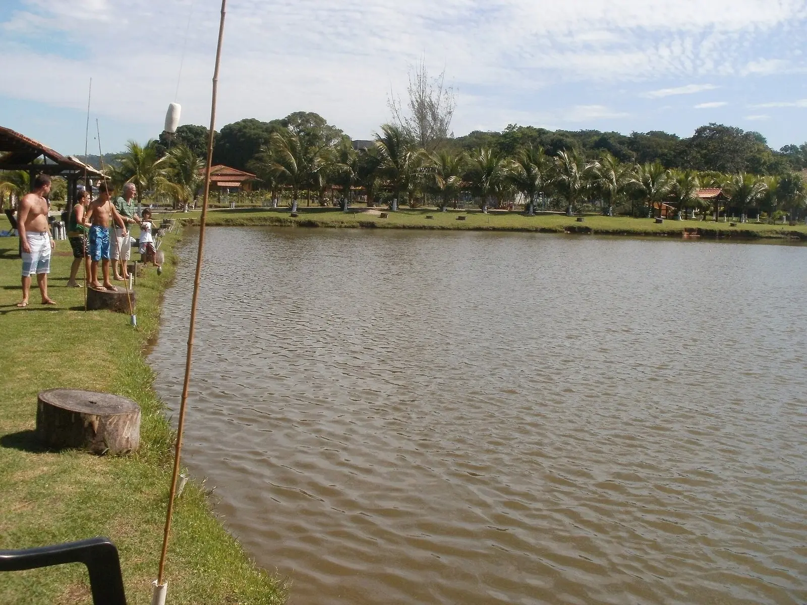 Pescadores lado a lado com varas de bambu na margem de um pesque-pague na zona oeste do Rio de Janeiro